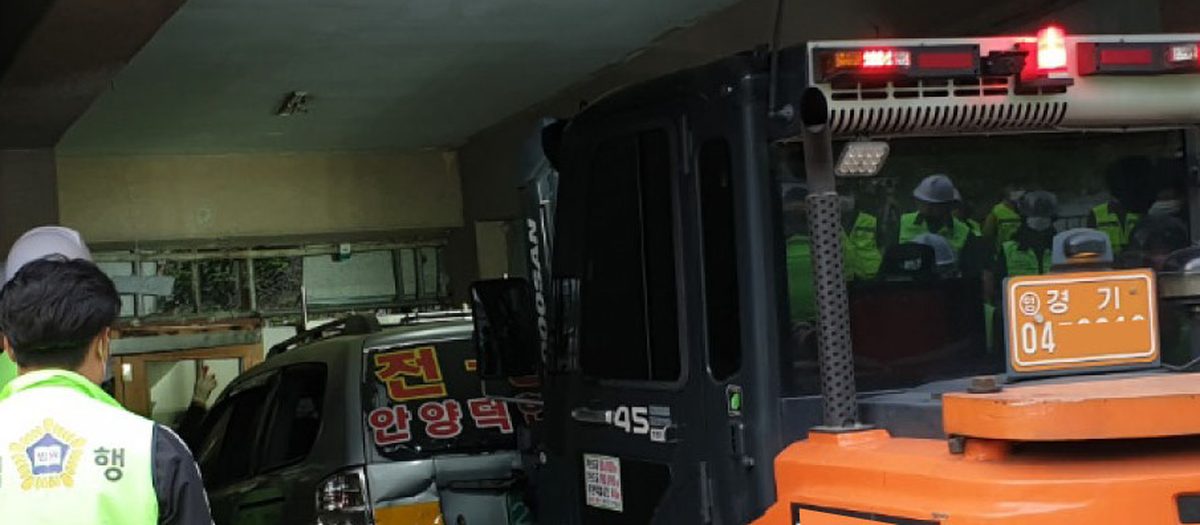명도집행 현장. 철거민 현수막 아래로 지게차가 들어가는 모습